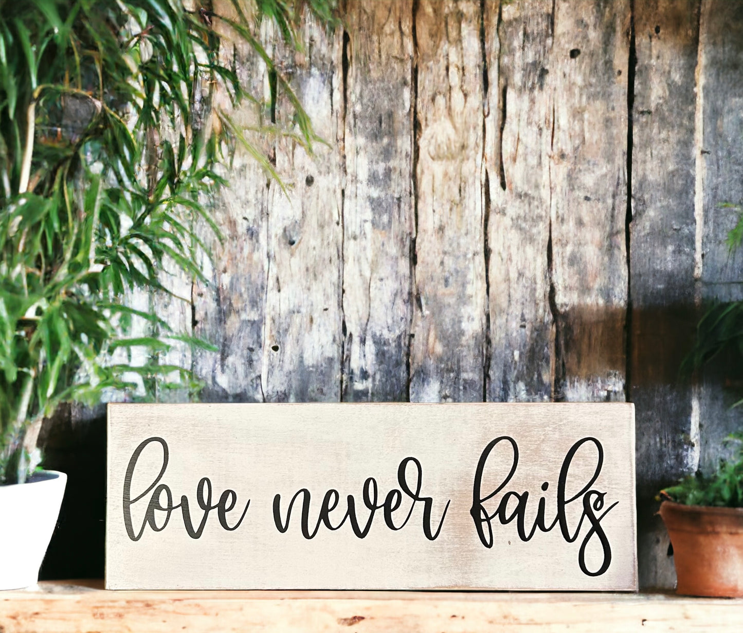 "Love never fails" wood sign