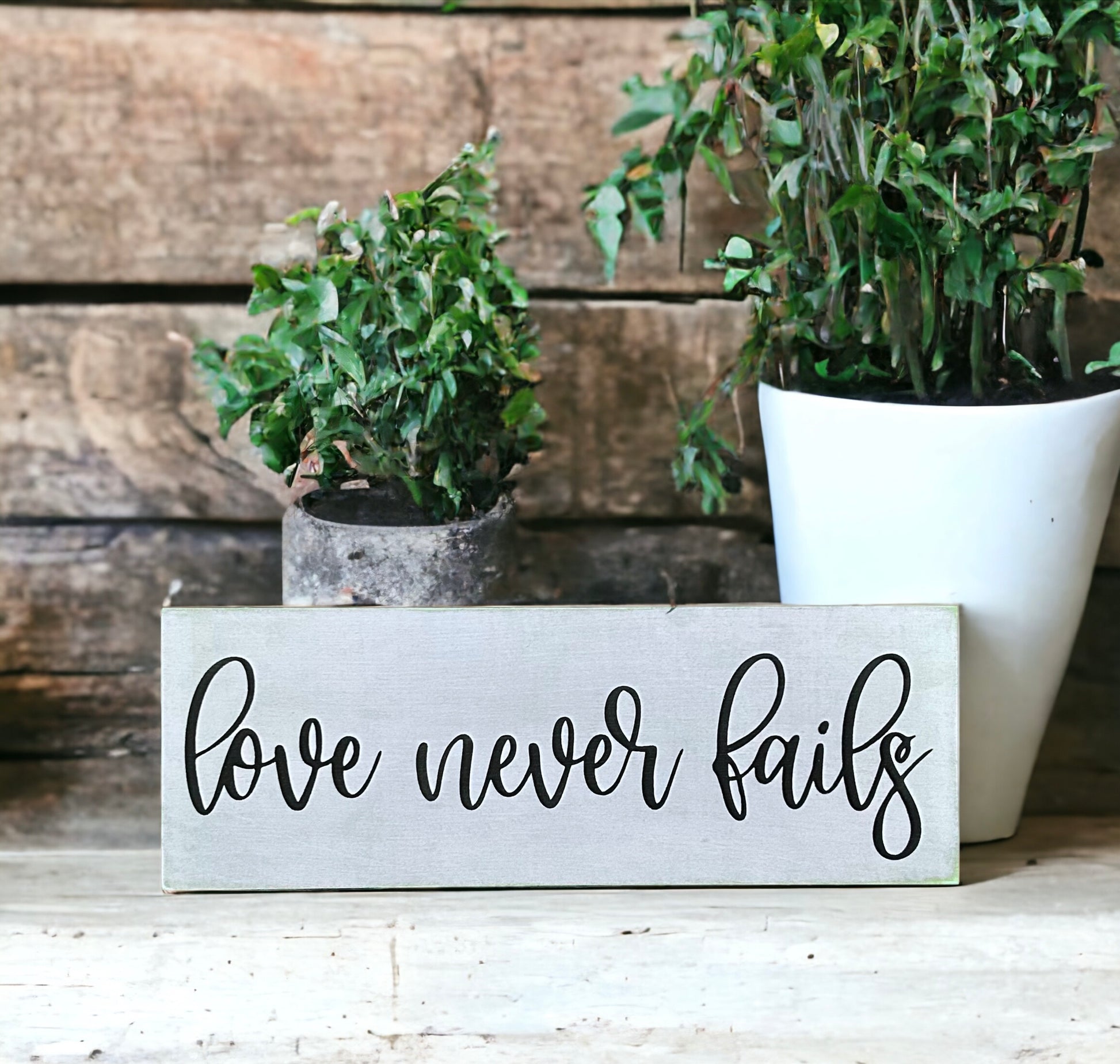 "Love never fails" wood sign