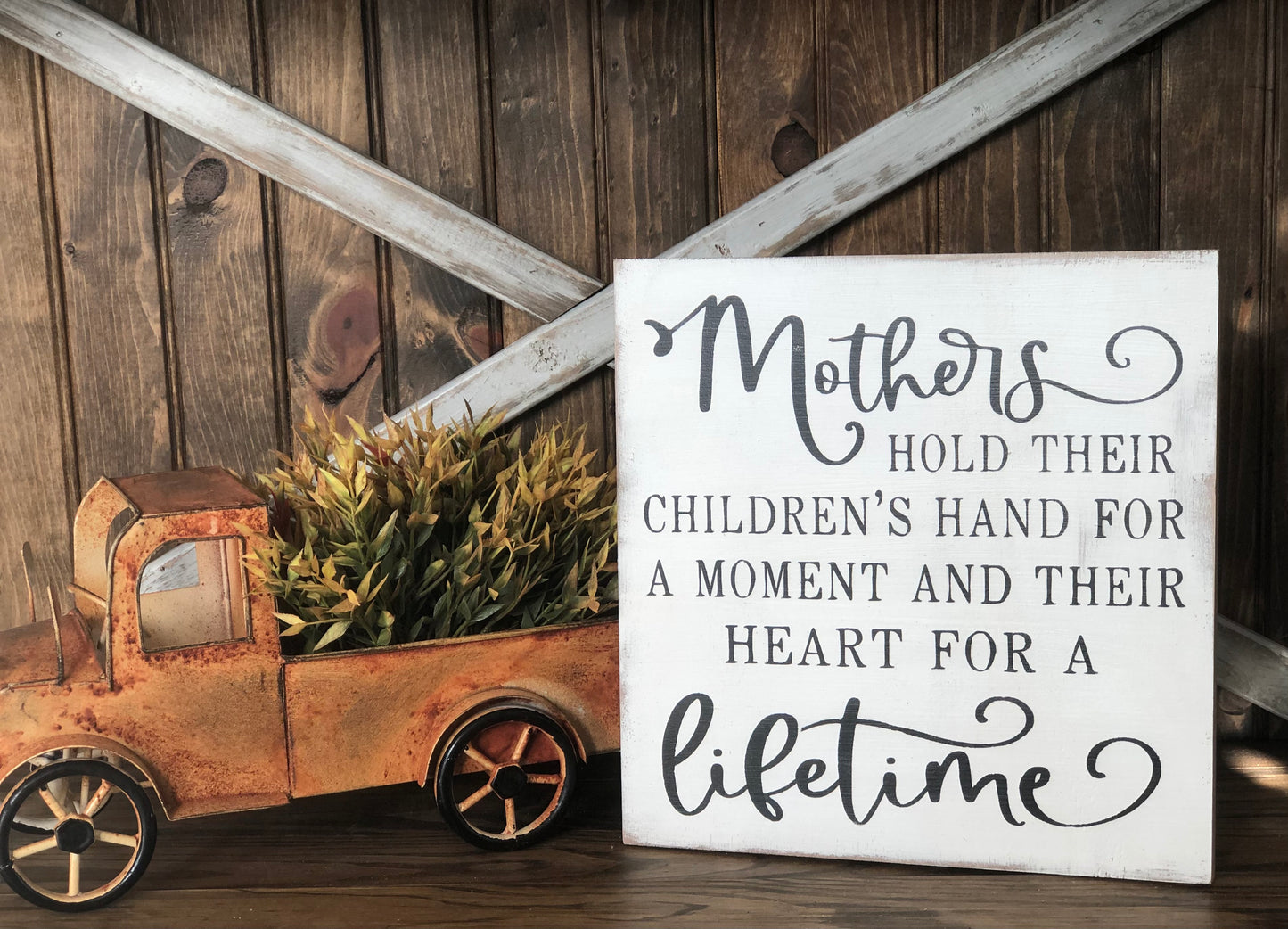 "Mothers hold their childrens hand" wood sign